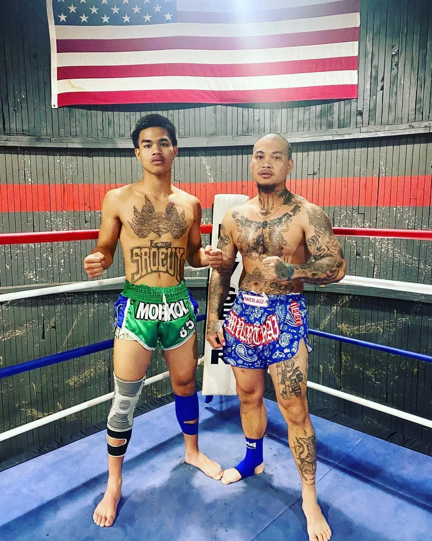 Two South Sound fighters standing in the gym ring beneath the American flag