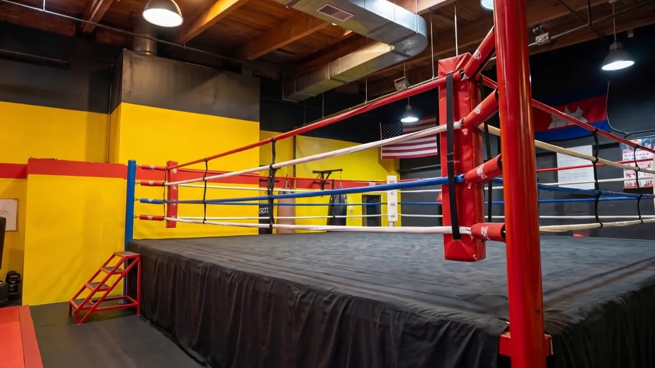 The ring seen low from the training mats, red corner post in the foreground