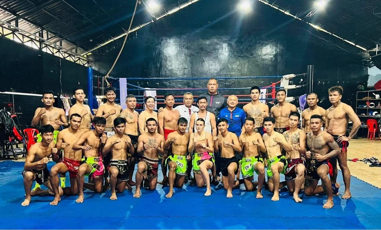 Kun Khmer fighters and coaches gathered around the ring at a training camp in Cambodia